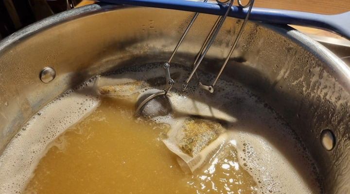 Teebeutel mit Kräutern in kochendem Bier